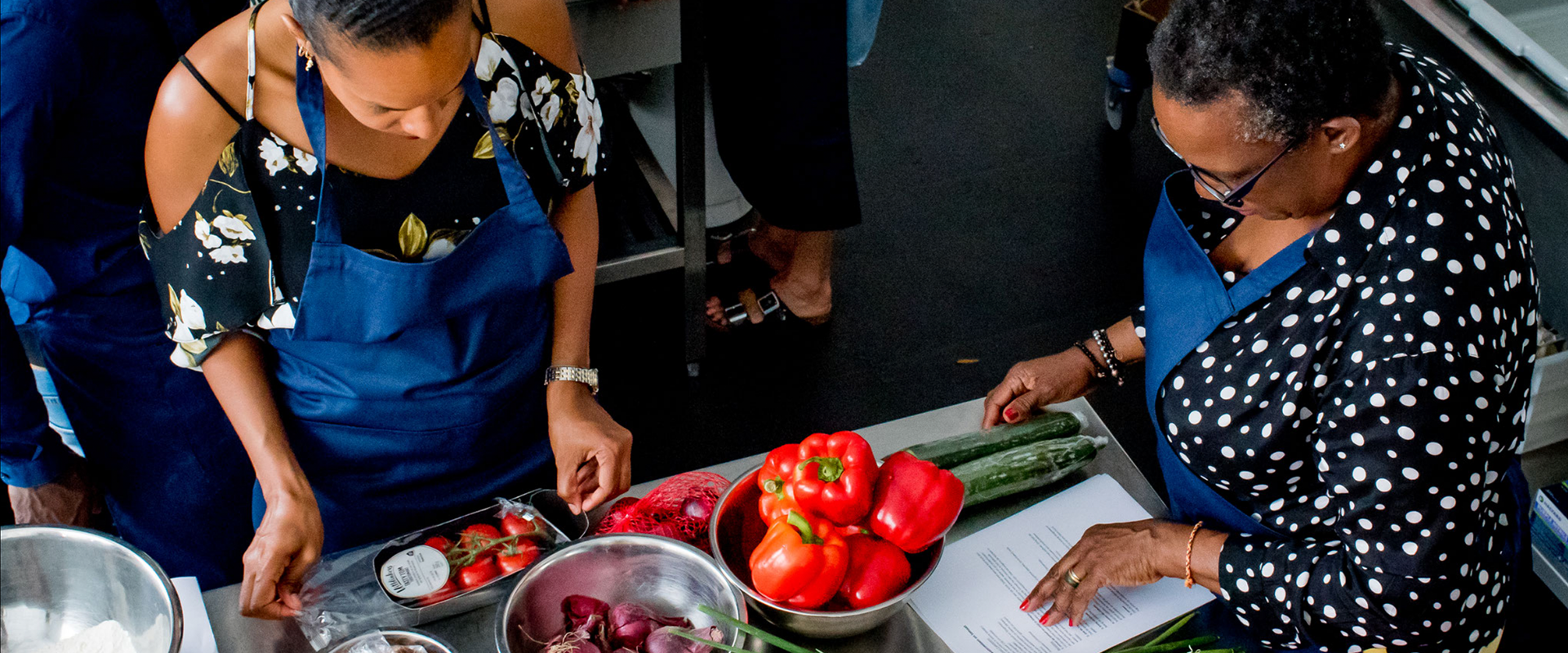 Twee dames aan het koken tijdens een kookworkshop