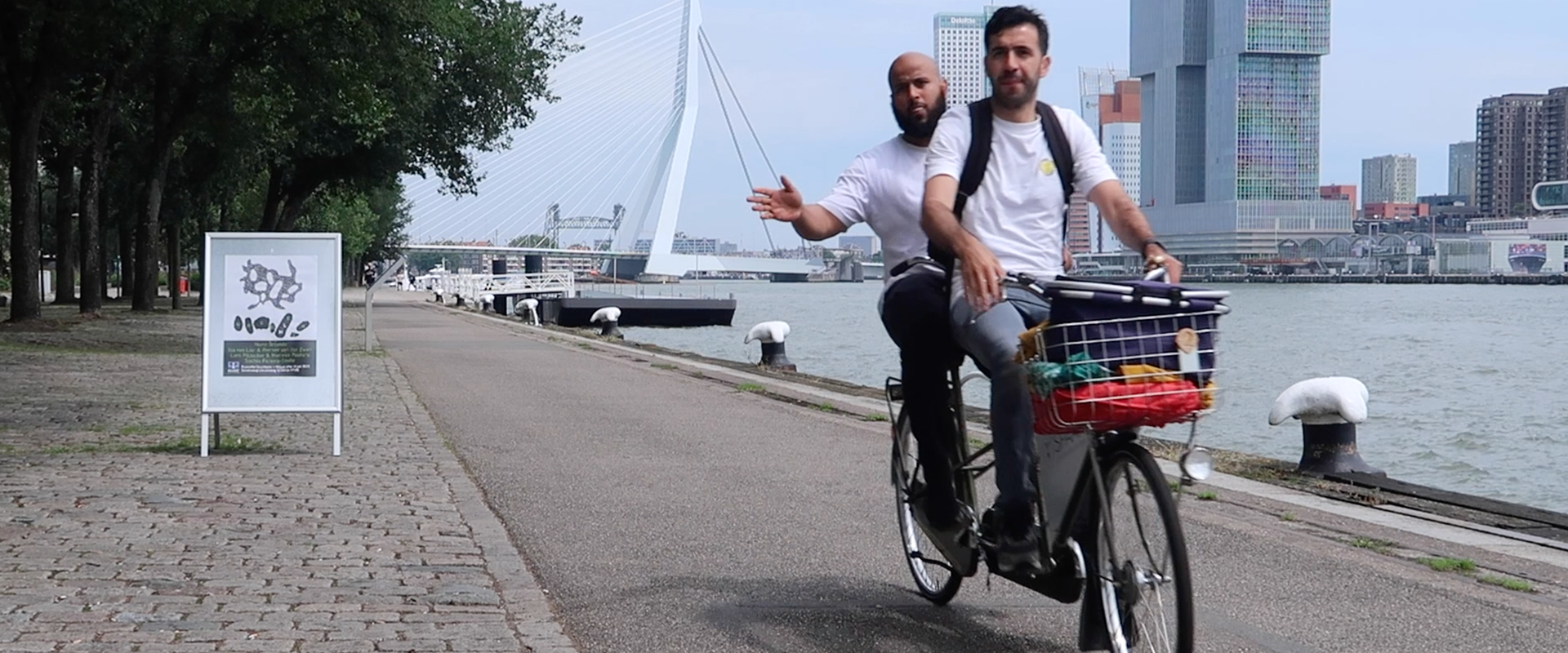 Marco en Musa op een tandem voor de Erasmusbrug